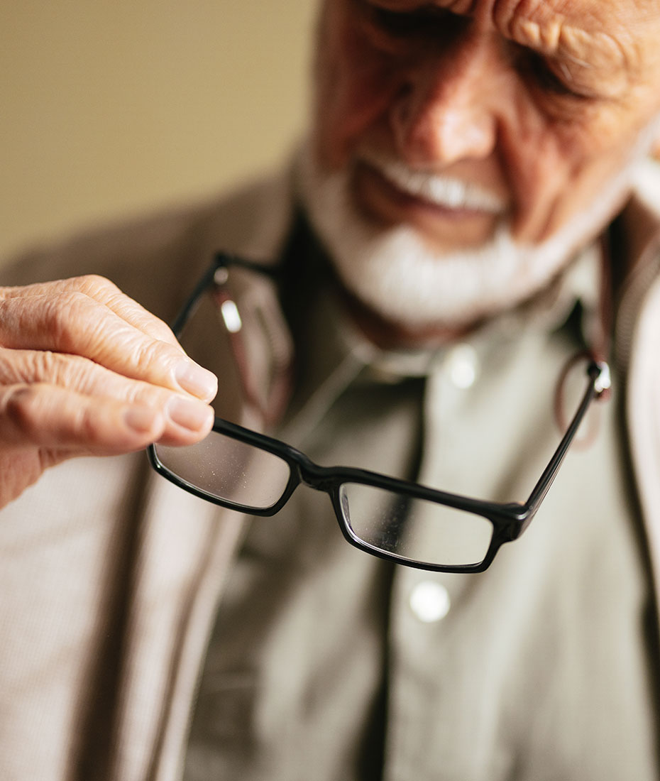 Mann hält Brille