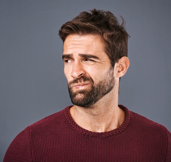 Mann verzieht das Gesicht, sieht nachdenklich aus. 